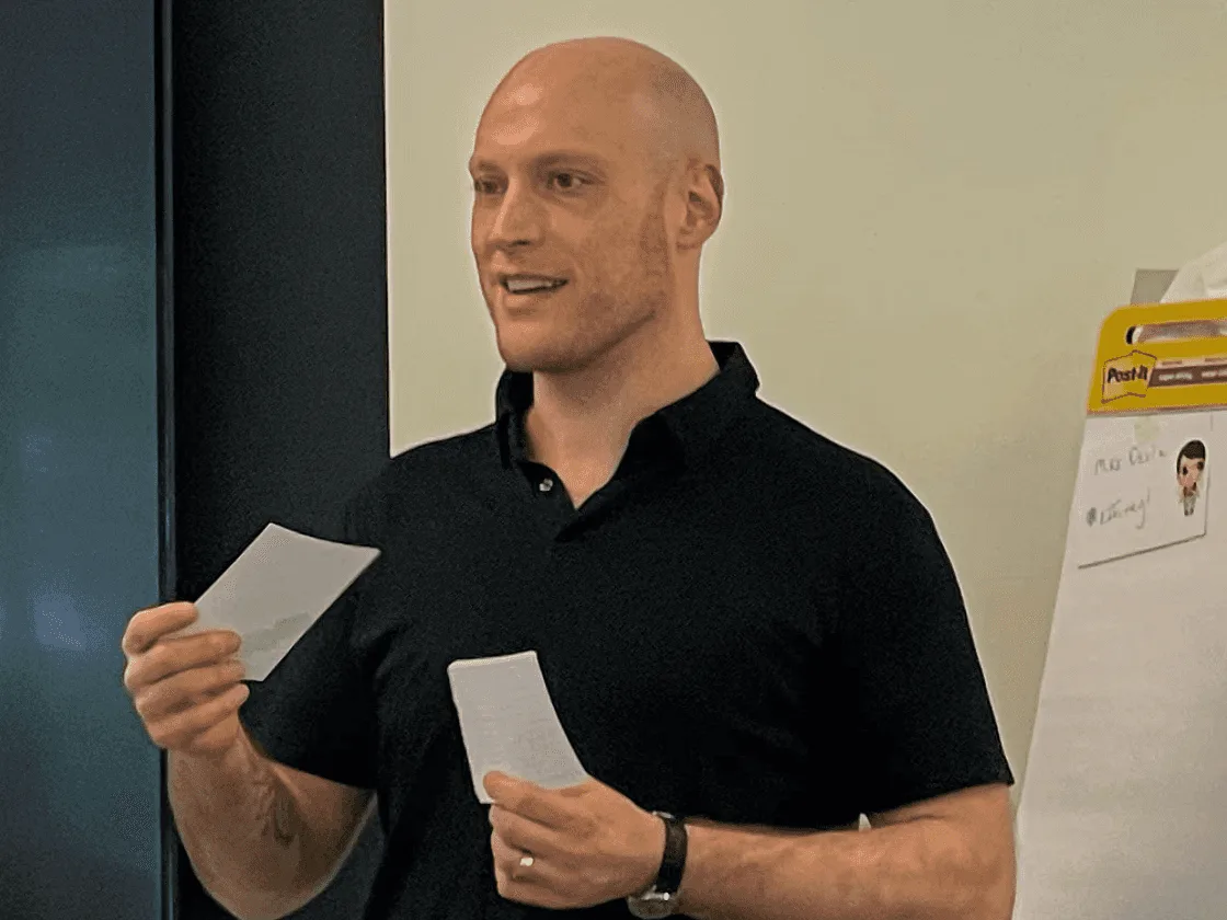 Luis Cielak leading a product strategy workshop, holding note cards beside a flip chart.